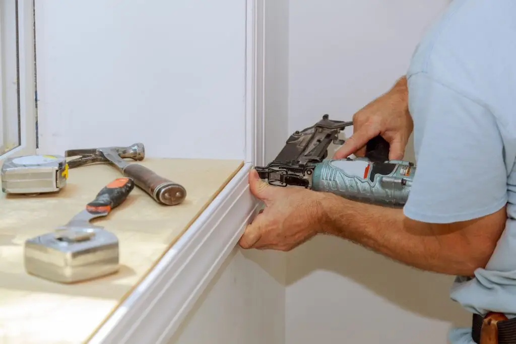 worker installing trim around a window molding installed moldings materials 1